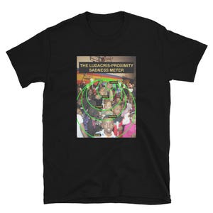 May include: A black short-sleeved t-shirt featuring a graphic print of a crowd of people in a gymnasium. The print includes the text THE LUDACRIS-PROXIMITY SADNESS METER and a series of concentric green circles labelled with various emotional states.