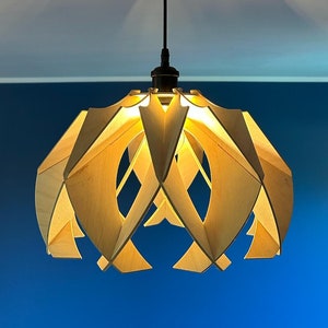 Op de afbeelding: Een moderne, houten hanglamp met een geometrisch ontwerp. De lamp is gemaakt van natuurlijk hout en heeft een warme, uitnodigende gloed.