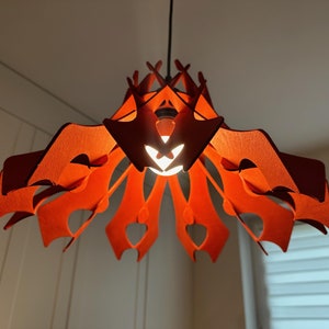 Könnte beinhalten: Eine rote, mehrschichtige, geometrische Pendelleuchte mit modernem Design.