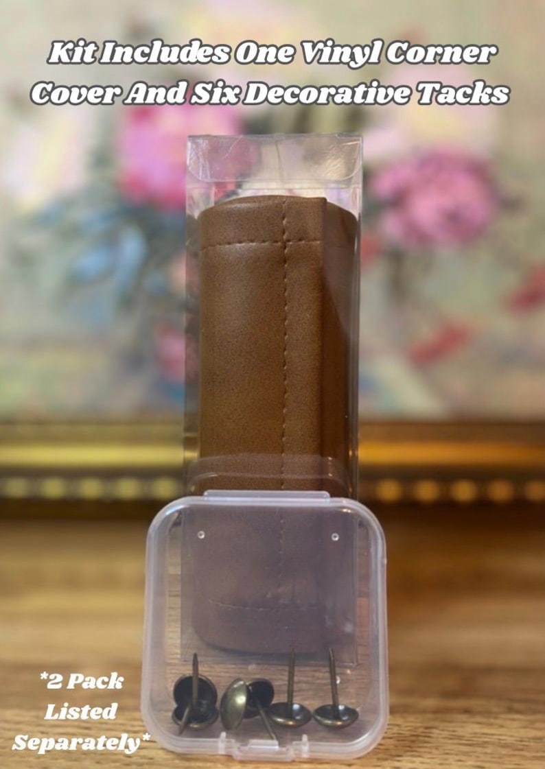 May include: A kit containing a brown vinyl corner cover and six decorative tacks, packaged in a clear plastic container. The text on the image reads "Kit Includes One Vinyl Corner Cover And Six Decorative Tacks" and "*2 Pack Listed Separately*".