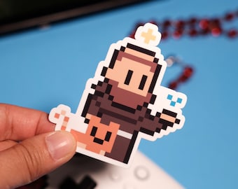 May include: A pixel art sticker of a brown-skinned person with a halo and a beard, wearing a brown robe and holding a small, orange cat. The person is smiling and has a blue glow around their hand.