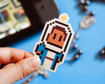 May include: A pixelated sticker of a person with brown skin wearing a blue and white outfit. The person has a yellow halo above their head. The sticker is on a blue surface.
