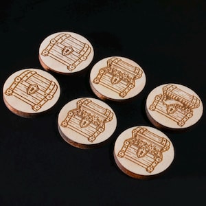 May include: Six circular light-colored wooden tokens, each featuring a laser-engraved illustration of a treasure chest. Some chests are depicted as closed, while others are shown open, revealing contents inside. The tokens have a smooth finish.