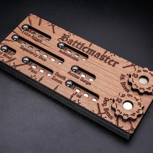 Puede incluir: Juego de mesa de madera titulado "Battlemaster" con texto grabado y marcadores de bolas metálicas. Cuenta con diales para ajustes de bonificación. Incluye etiquetas como "Extra Attack" y "Action Surge".