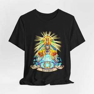 May include: Black t-shirt featuring a colourful illustration of a robot wearing a crown and holding a glowing orb. The robot is surrounded by a halo of light and flowers. The text "ILYA  ILYA  ILYA" is printed below the robot.