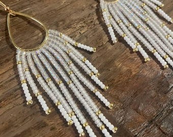 Pendientes de flecos con cuentas blancas y doradas: joyas elegantes y llamativas para espíritus libres.