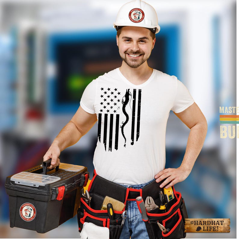 May include: A white t-shirt featuring a black graphic of the American flag with a dragon silhouette replacing the stripes. The shirt is worn with a white hard hat, blue jeans, and a black tool belt filled with various tools and a black toolbox.