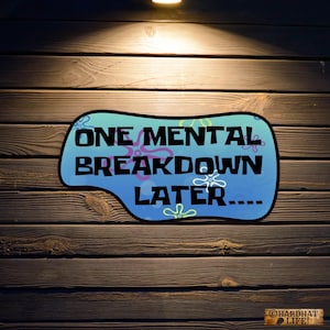 May include: A blue and pink cartoon speech bubble with the text "ONE MENTAL BREAKDOWN LATER..." on a wooden background.