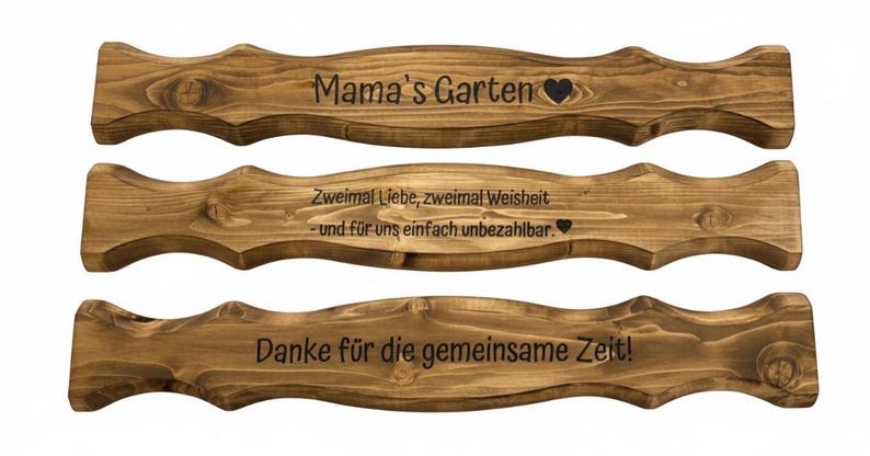 Puede incluir: Tres letreros de madera con un dise&ntilde;o ondulado y tinte marr&oacute;n oscuro. El letrero superior dice "Mama's Garten" con un coraz&oacute;n. El letrero del medio dice "Zweimal Liebe, zweimal Weisheit - und f&uuml;r uns einfach unbezahlbar." El inferior dice "Danke f&uuml;r die gemeinsame Zeit!"