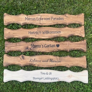 Puede incluir: Una colecci&oacute;n de letreros de madera con bordes decorativos, cada uno grabado con texto. Los letreros son de varios tonos de marr&oacute;n y uno es de color claro. El texto incluye frases como "Mama's Garden" y nombres como "Rebecca y Marvin".