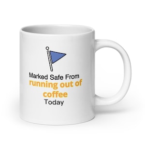 May include: White ceramic coffee mug with a blue and black flag icon and the text "Marked Safe From running out of coffee Today".