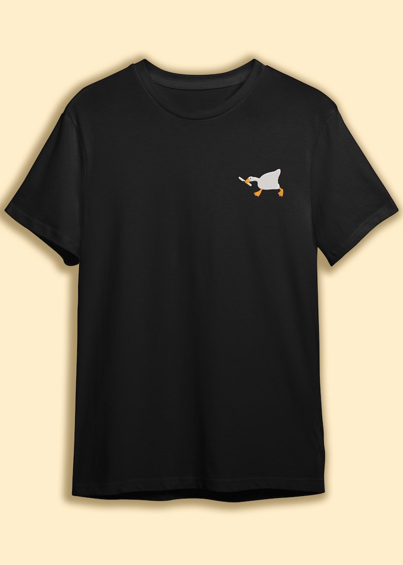 May include: A black t-shirt with a white embroidered image of a goose holding a knife.