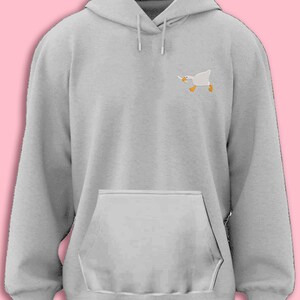 May include: A gray hooded sweatshirt with a small embroidered image of a white goose holding a knife in its beak.