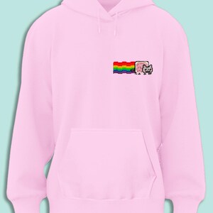 A pink hoodie with a rainbow graphic and a cat graphic on the front.