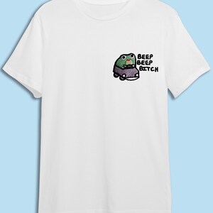 A white t-shirt with a small cartoon frog on the front.