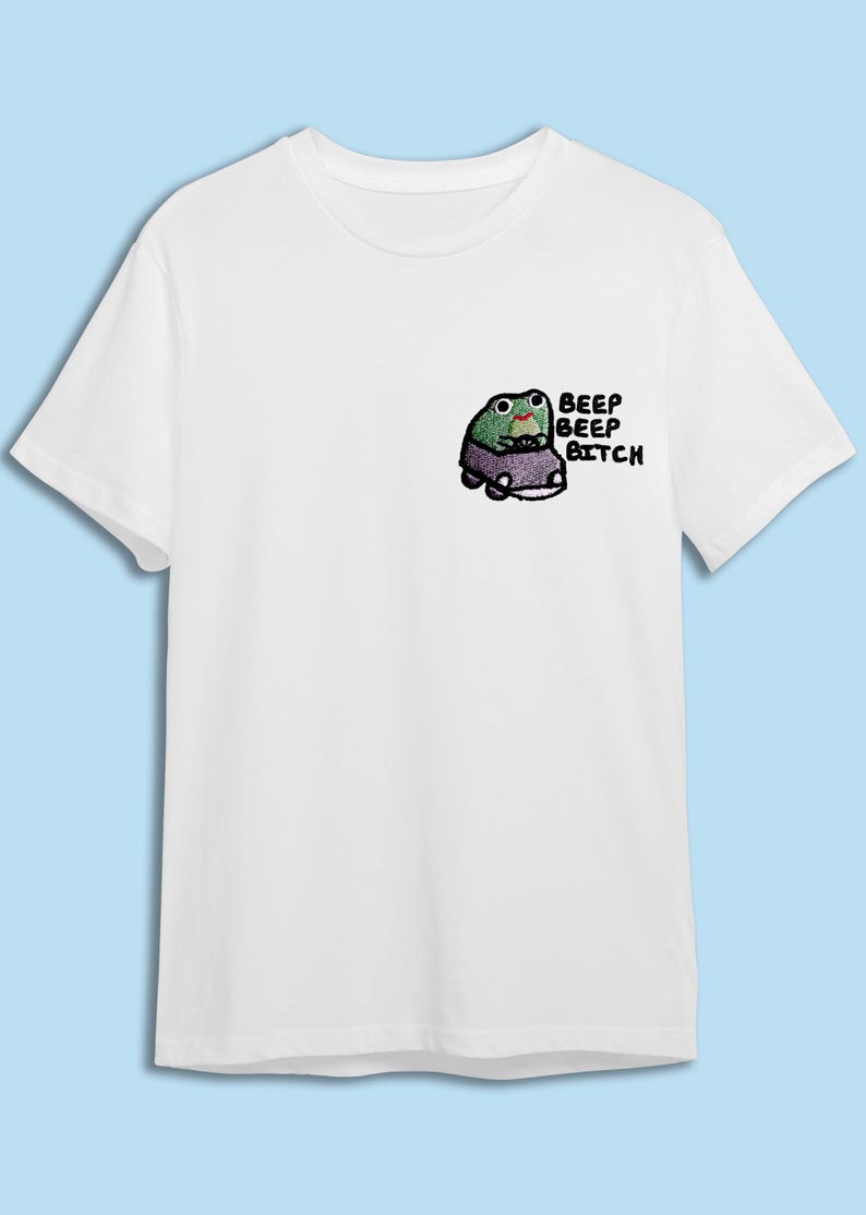 A white t-shirt with a small cartoon frog on the front.