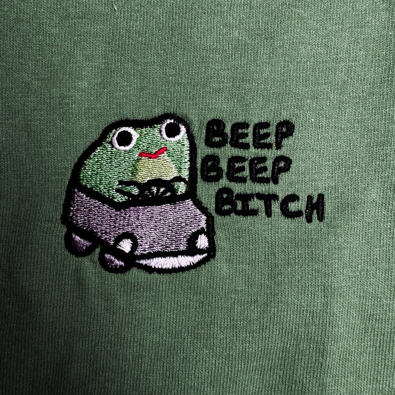 a green frog with a car, accompanied by the text "BEEP BEEP BITCH" in a playful, humorous manner.