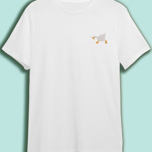 May include: White t-shirt with a small embroidered image of a white goose running with its wings outstretched.