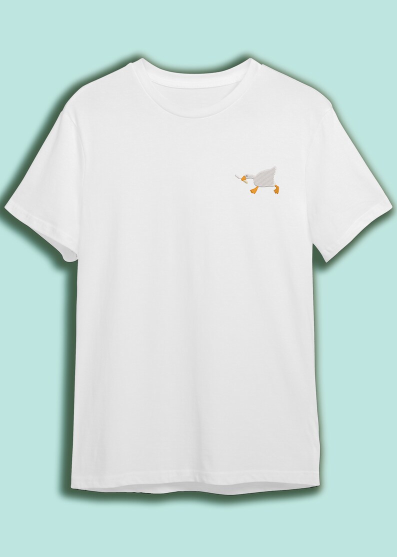 May include: White t-shirt with a small embroidered image of a white goose running with its wings outstretched.