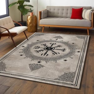 Könnte beinhalten: Ein rechteckiger Teppich mit hellgrauem Hintergrund und einem schwarzen geometrischen Design. Das zentrale Design ist ein kreisförmiges, kompassartiges Symbol, umgeben von einem Rand mit komplizierten Mustern. Der Teppich liegt auf einem Holzboden.