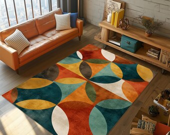 May include: A rectangular area rug with a geometric pattern. The rug features overlapping shapes in shades of orange, teal, brown, yellow, and white. The rug is placed on a wooden floor in a living room setting.