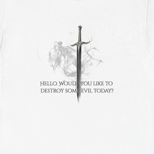 May include: White t-shirt featuring a stylized sword design with a smoky background. The text "HELLO. WOULD YOU LIKE TO DESTROY SOME EVIL TODAY?" is printed below the sword. A casual, graphic tee.