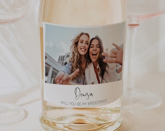 Peut inclure: Une bouteille de vin blanc avec une étiquette qui dit "Denis, Veux-tu être ma demoiselle d'honneur ?" et qui présente une photo de deux femmes souriantes et riantes.
