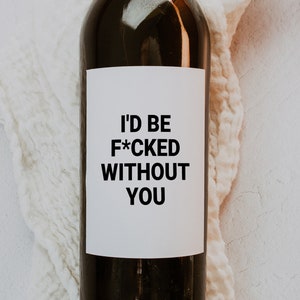 Puede incluir: Una botella de vino negra con una etiqueta blanca que dice "I'd be F*CKED without you".