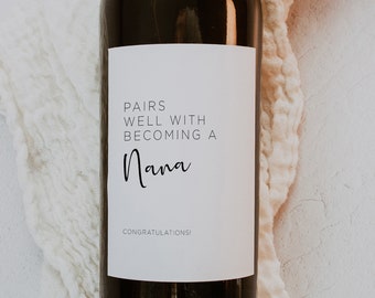 May include: A white wine bottle label with black text that reads "Pairs well with becoming a Nana. Congratulations!"