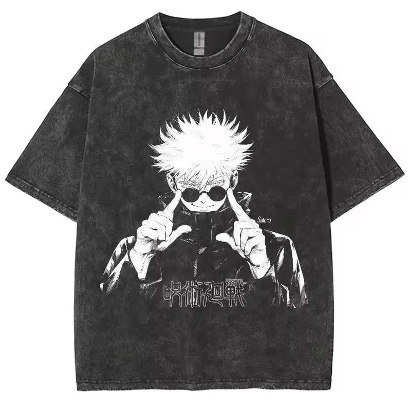 May include: Dark gray t-shirt featuring a white graphic of an anime character with sunglasses, pointing at their eyes. The shirt has the Japanese text "呪術廻戦" and the name "Satoru" printed on it. The shirt has a vintage, washed look.