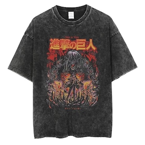 Op de afbeelding: Donkergrijs t-shirt met een grafisch ontwerp met Japanse tekst en een gedetailleerde illustratie in rood, oranje en zwart. Het ontwerp bevat een centrale figuur met een skeletachtig uiterlijk en lang haar.