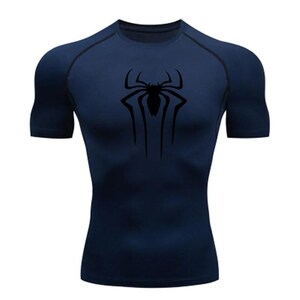 Puede incluir: Una camiseta de manga corta azul marino con un gr&aacute;fico de ara&ntilde;a negra en la parte delantera.
