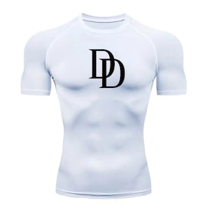 Pode incluir: Camiseta de compressão branca de manga curta com um logotipo "DD" preto na frente.