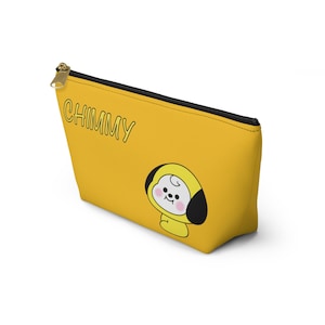 May include: Yellow zippered pouch with a black zipper and black trim. The pouch has a cartoon image of a yellow dog with black ears and a white face. The text "CHIMMY" is printed in black on the pouch.
