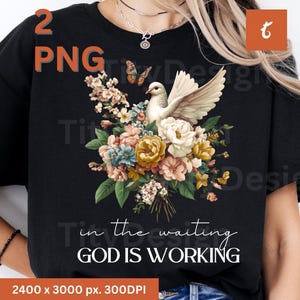 Peut inclure: T-shirt noir avec un motif floral représentant une colombe blanche et le texte "Dans l'attente, Dieu travaille".