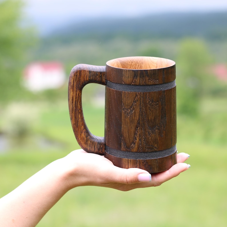 20 oz handcrafted wooden cup shown in hand for scale.