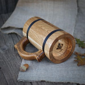 Oak mug on a wooden table, surrounded by rustic decor, capturing the mug's eco-friendly and handmade charm.
