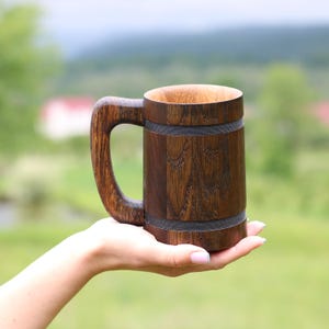 Oak beer mug in a natural green landscape background.