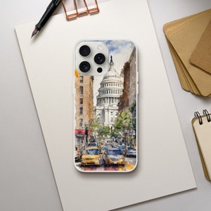 May include: A clear phone case featuring a watercolor painting of a city street with yellow taxis and a large white building with a dome. The case is on a white surface with a pen and stationery.