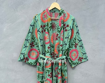 May include: A long, teal blue robe with a floral embroidery pattern. The robe has a tie belt and long sleeves.