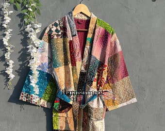 May include: A colorful patchwork quilted robe with a long sleeve and a tie belt. The robe is made of various fabrics in shades of pink, blue, green, brown, and beige.