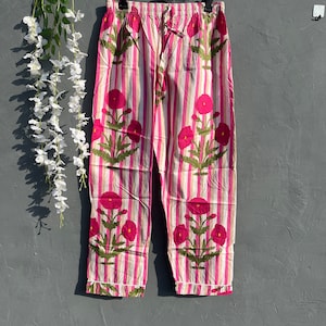 Puede incluir: Pantal&oacute;n de pijama a rayas rosa y blanco con estampado floral. El pantal&oacute;n tiene una cintura el&aacute;stica y un cord&oacute;n.