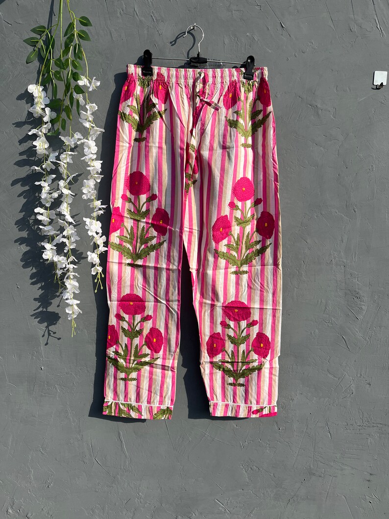 Puede incluir: Pantal&oacute;n de pijama a rayas rosa y blanco con estampado floral. El pantal&oacute;n tiene una cintura el&aacute;stica y un cord&oacute;n.