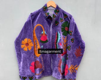 May include: A purple velvet jacket with colorful floral embroidery. The jacket features a zip-up front and a striped lining. The embroidery includes orange, green, pink, and blue flowers and leaves. The text "llmagarment" is visible on the front.