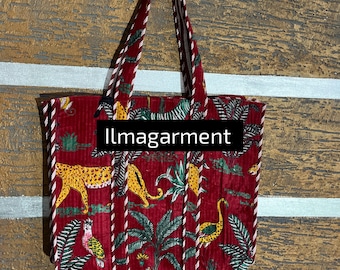 May include: Red tote bag with a jungle-themed pattern featuring yellow leopards, birds, and foliage. The bag has a striped trim and handles. The text "llmagarment" is printed on the front.