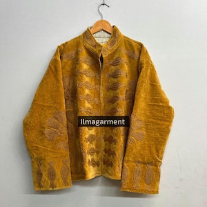 May include: Mustard yellow jacket with detailed floral embroidery. The jacket has a mandarin collar and long sleeves with ornate cuffs. The text "llmagarment" is visible on the front of the jacket.