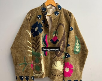 May include: A brown jacket with colorful floral embroidery. The jacket features a high collar and is adorned with blue, pink, green, and white flowers, along with a paisley design. The text "llmagarment" is visible on the jacket.
