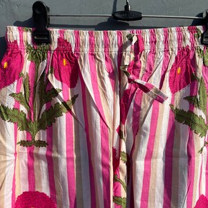Puede incluir: Pantal&oacute;n de pijama a rayas rosa y blanco con estampado floral. El pantal&oacute;n tiene una cintura el&aacute;stica y un cord&oacute;n.