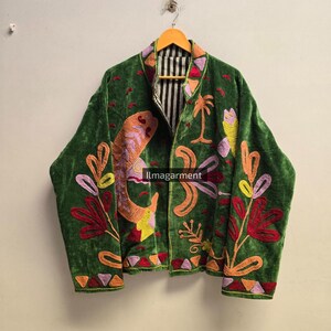 Jaqueta boho de veludo verde bordada à mão com estampa floral de pássaros e estilo folk art. Casaco aberto na frente.