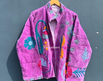 May include: A vibrant purple velvet jacket with colorful floral embroidery. The jacket features a striped lining and is hanging on a wooden hanger. The text "ilmagarment" is visible on the jacket.